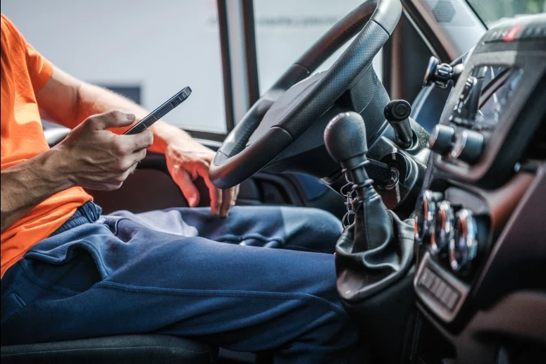 delivery truck driver browsing internet using phone