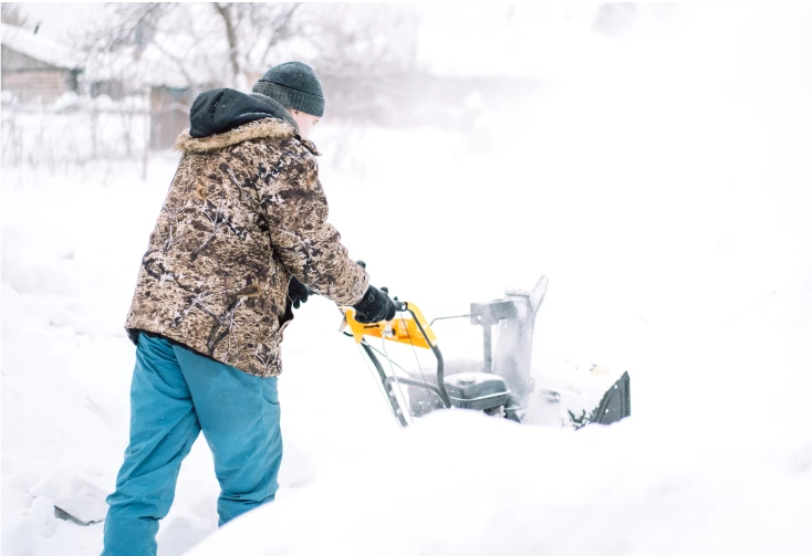 man cleaning snowed driveway